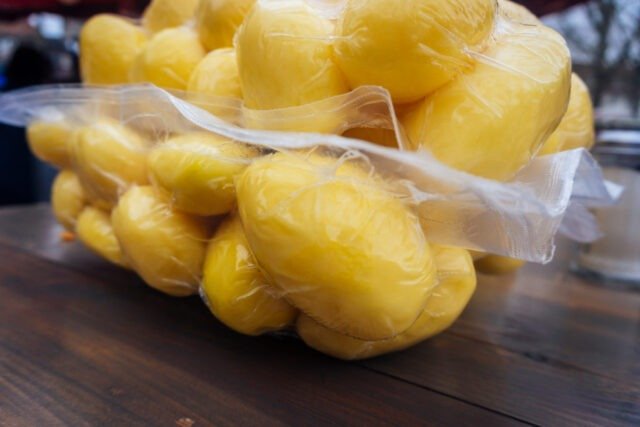 Freshly,Peeled,Potatoes,Wrapped,In,Plastic,Wrap,On,A,Wooden